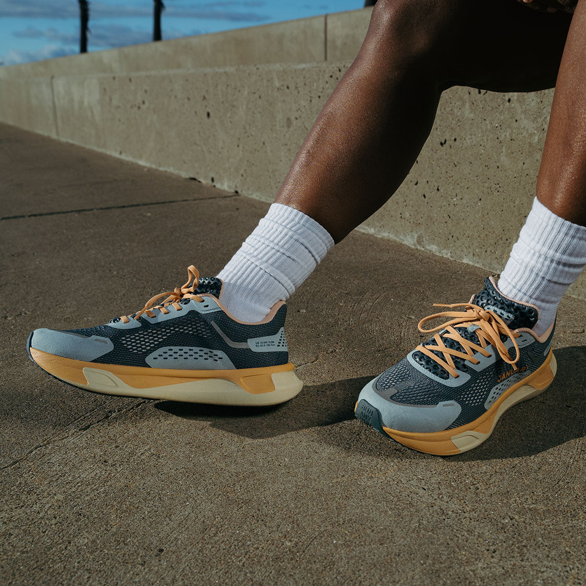 Person wearing Twilight Fog shoes with white socks on a concrete surface.
